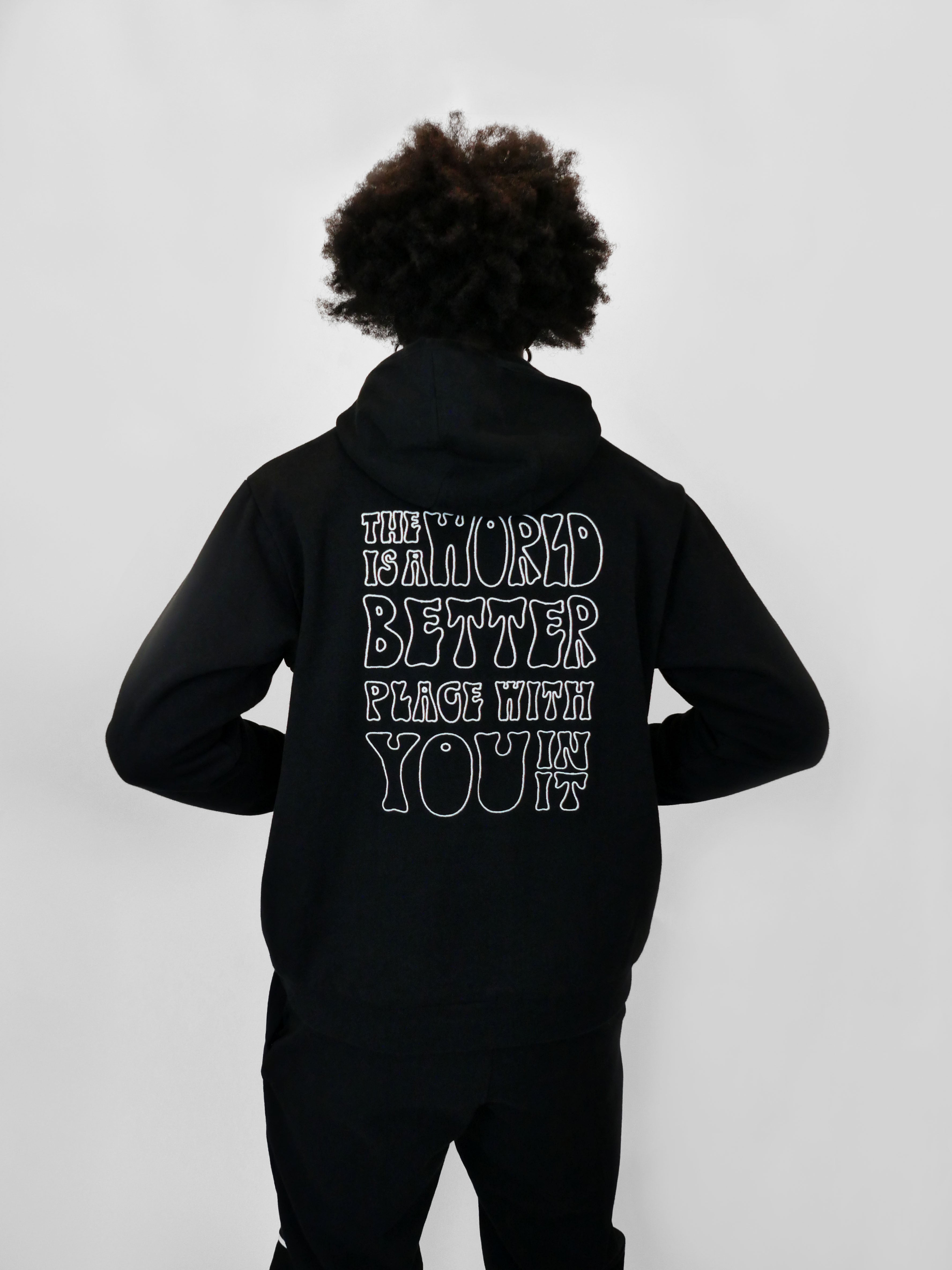 Person wearing a black hoodie with text on the back against a white background
