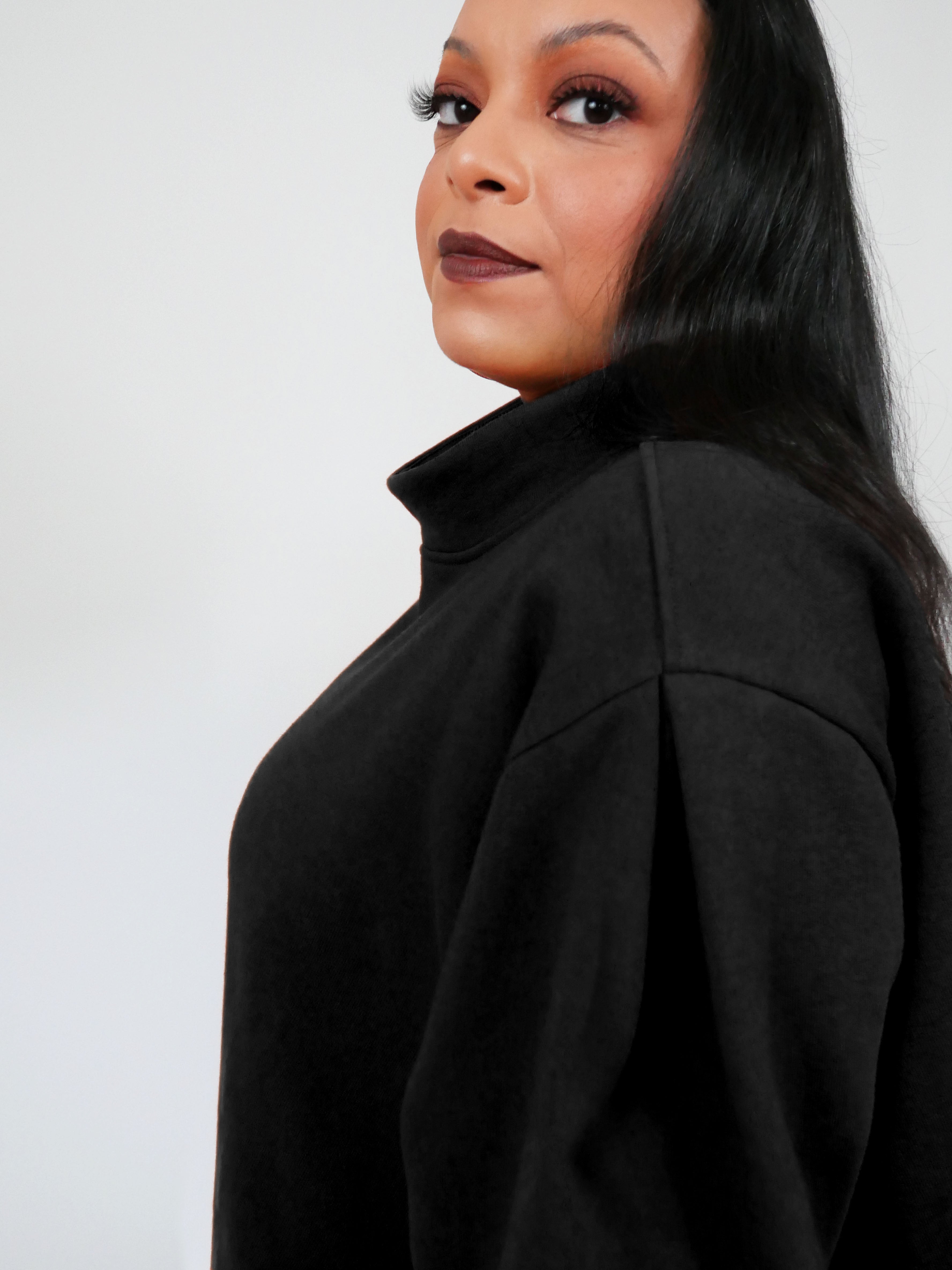 Woman wearing a black sweatshirt against a white background