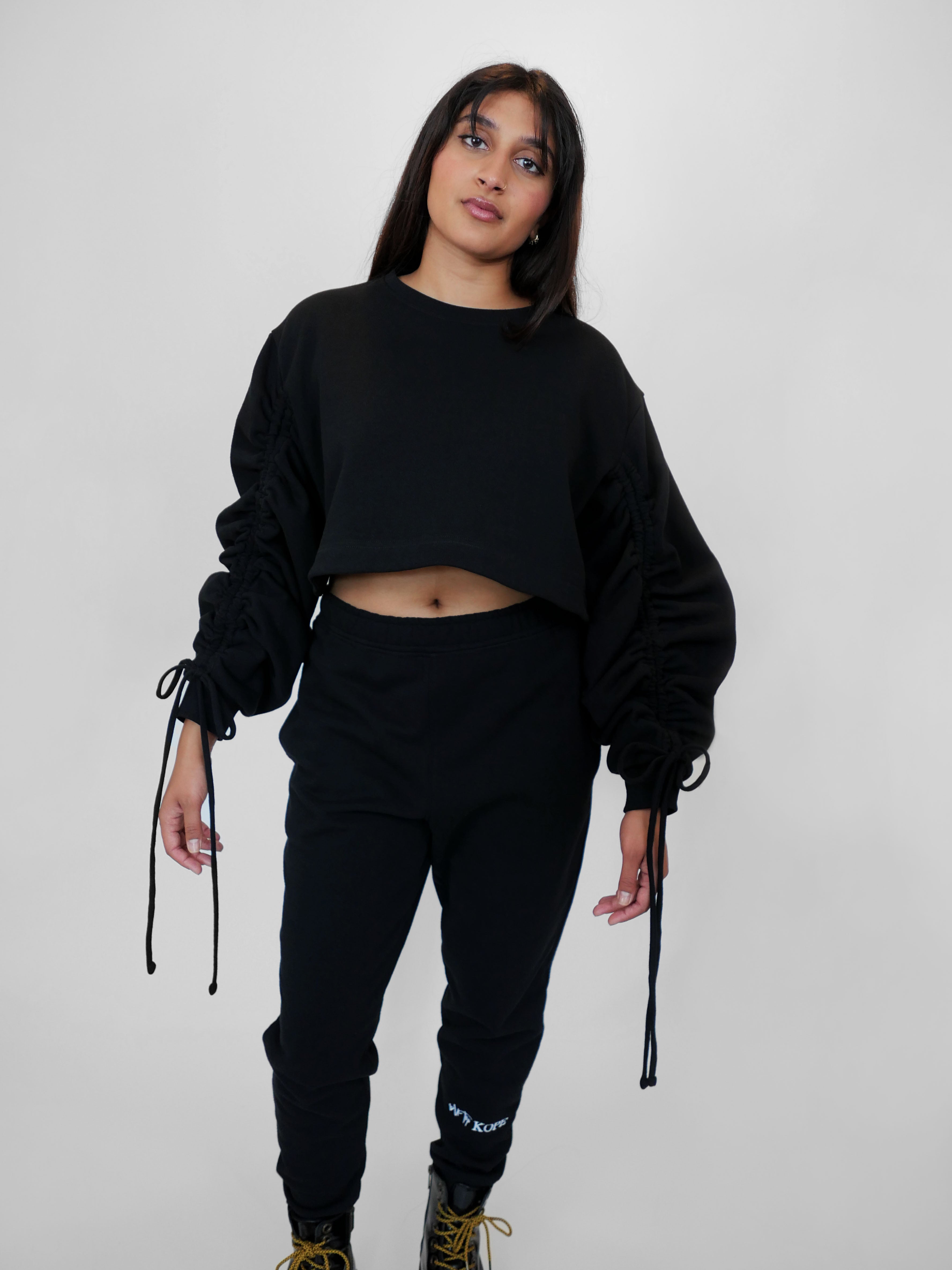 Person wearing a black outfit with a plain background