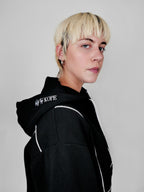 Person wearing a black full zip hoodie with 'blk top Kope' branding on a plain background