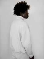 Person wearing a white tracksuit against a plain background