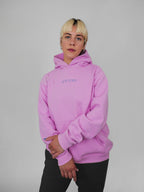 Person wearing a blush hoodie with text on a gray background