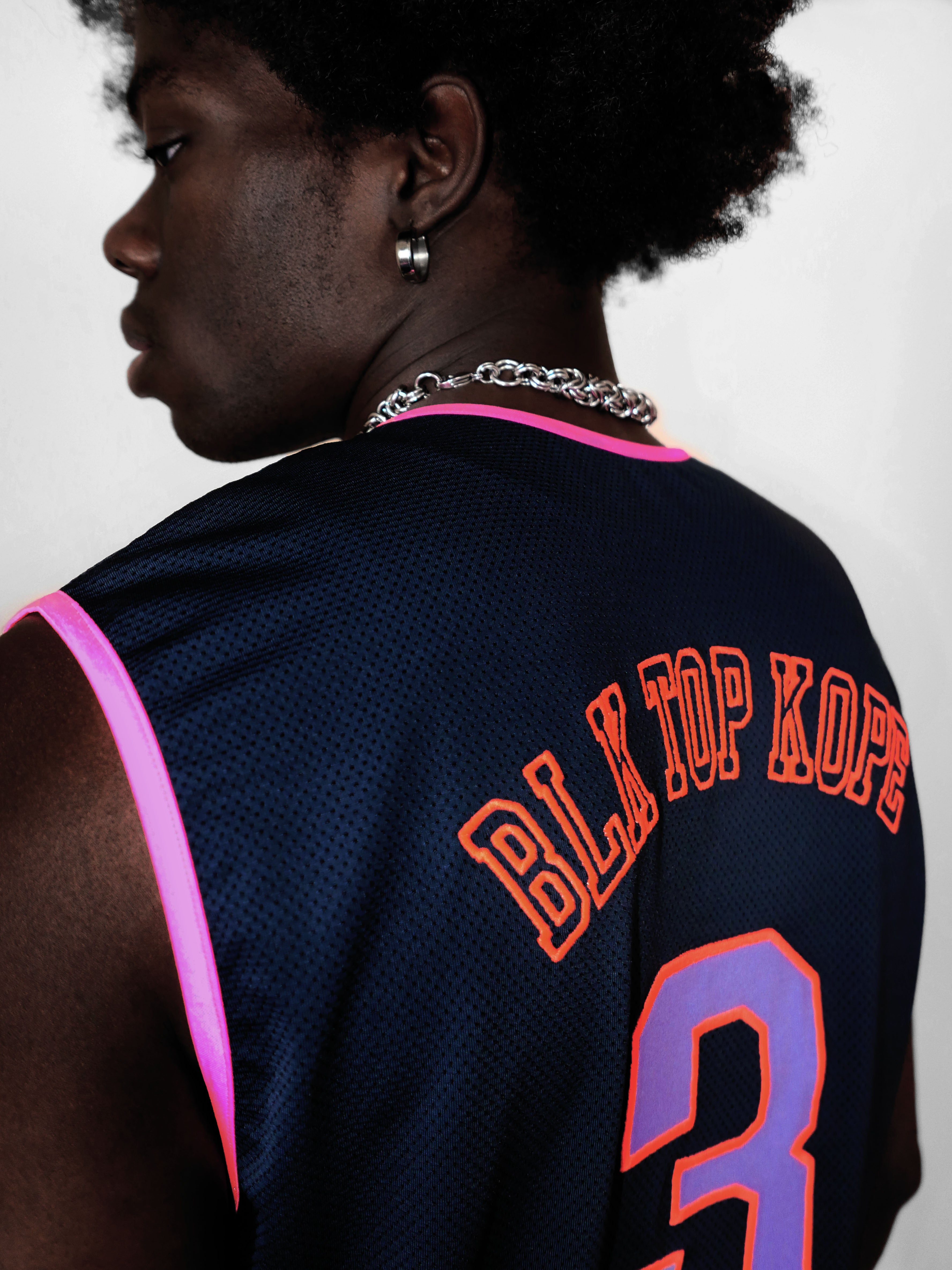 Man wearing a navy blue sports jersey with 'BLK TOP KOPE' and number '3' on a light gray background