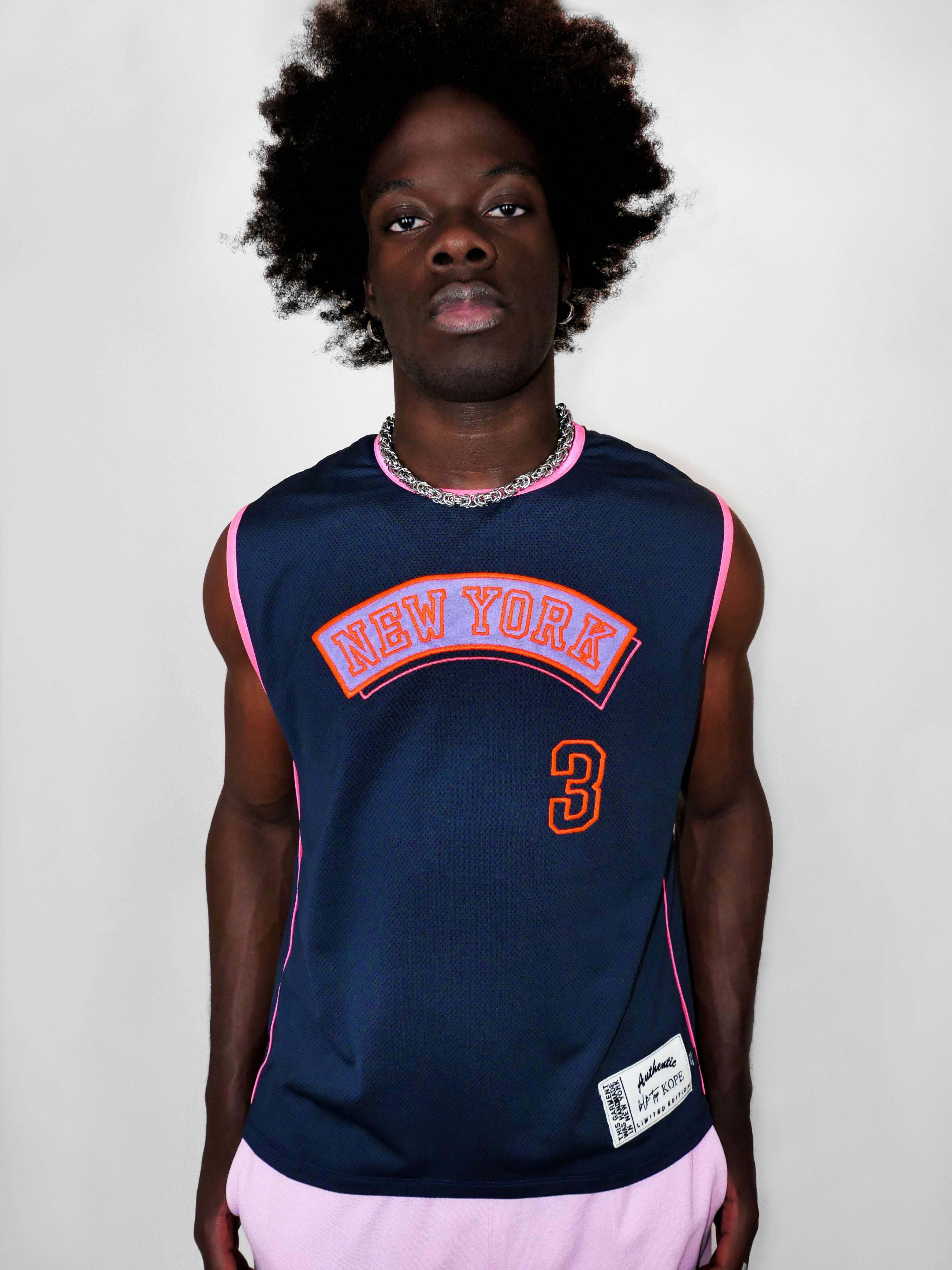 Man wearing a navy blue 'New York' jersey with pink accents and number 3 on a plain background
