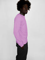 Person wearing a blush long-sleeve shirt against a white background