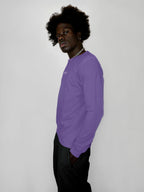 Person wearing a lavender long-sleeve shirt against a white background