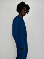 Person wearing a blue outfit with a brand logo on a white background