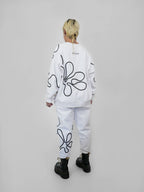 Person wearing a white outfit with black abstract one-line designs on a plain background