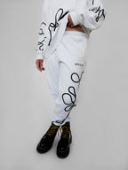 White sweatshirt and pants with black one-line design worn by a person on a light gray background