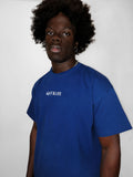 Person wearing a blue t-shirt with 'blk top KOPE' text on a plain background