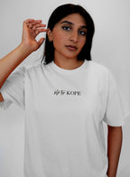 Person wearing a white t-shirt with 'blk top Kope' logo on a plain background