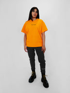Person wearing a yellow t-shirt with text and black sweatpants on a white background
