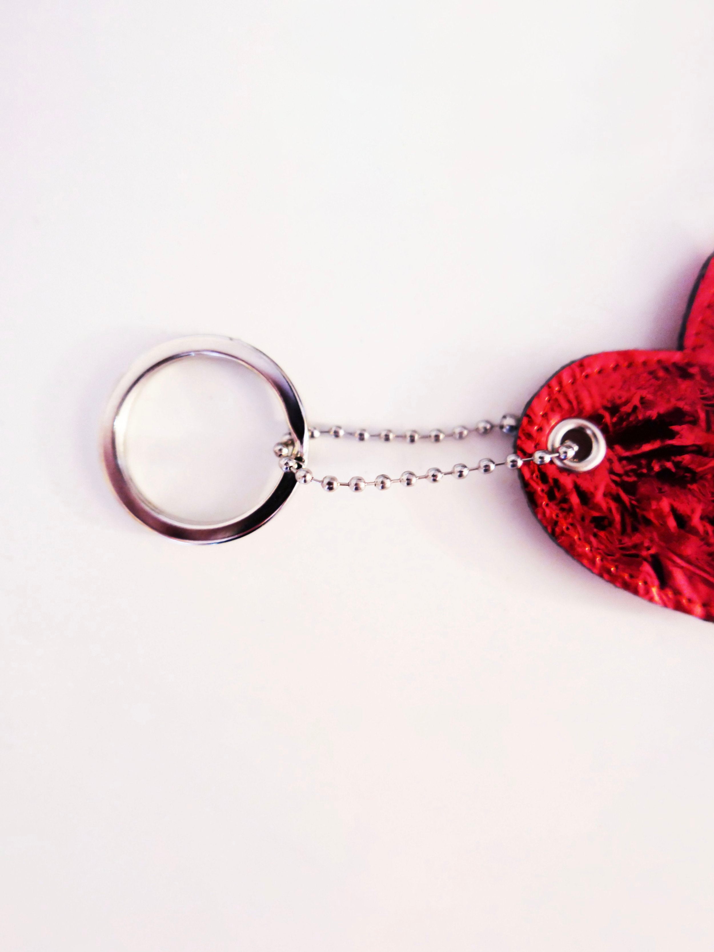 close up of a red heart-shaped keychain on a white background