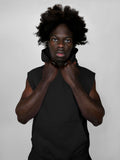 Person wearing a black sleeveless hoodie against a plain background