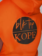 Orange sleeveless hoodie with 'BLK TOP Kope' logo on a gray background
