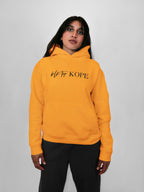 Person wearing a yellow hoodie with text on a plain background