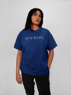 Person wearing a blue t-shirt with text on a plain background