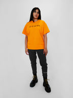 Person wearing a yellow t-shirt with text on a white background