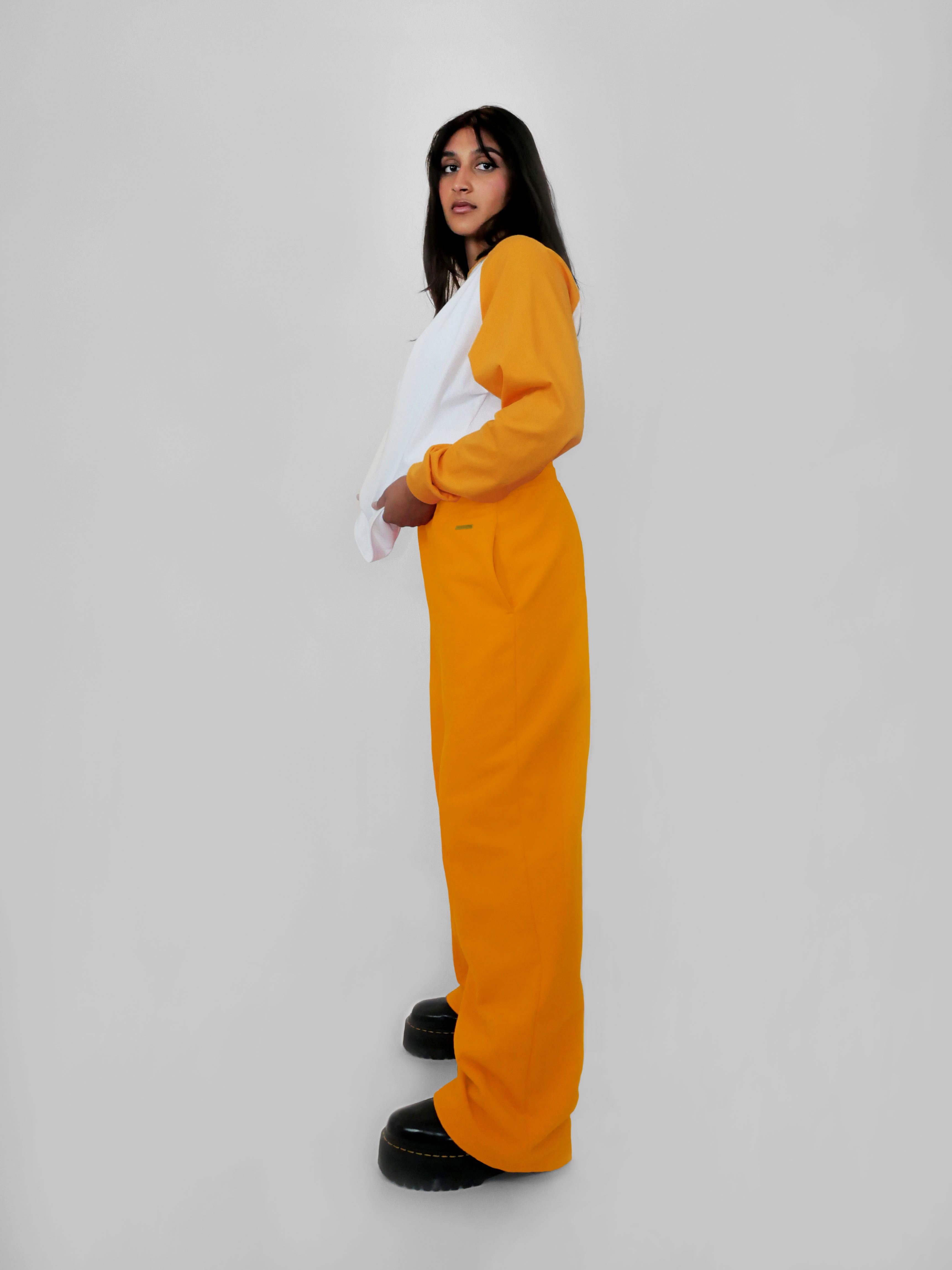 Person wearing yellow straight leg sweatpants against a white background