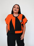 Person wearing an orange and black sweatervest on a white background