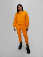 Person wearing a yellow tracksuit with black text on a white background