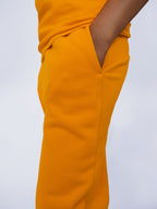 Closeup on pockets of yellow sweatpants on a plain background