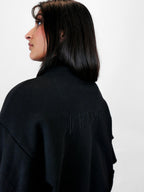 Person wearing a black volant jacket with 'blk top KOPE' branding on a white background