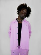 Person wearing a blush snap jacket on a white background