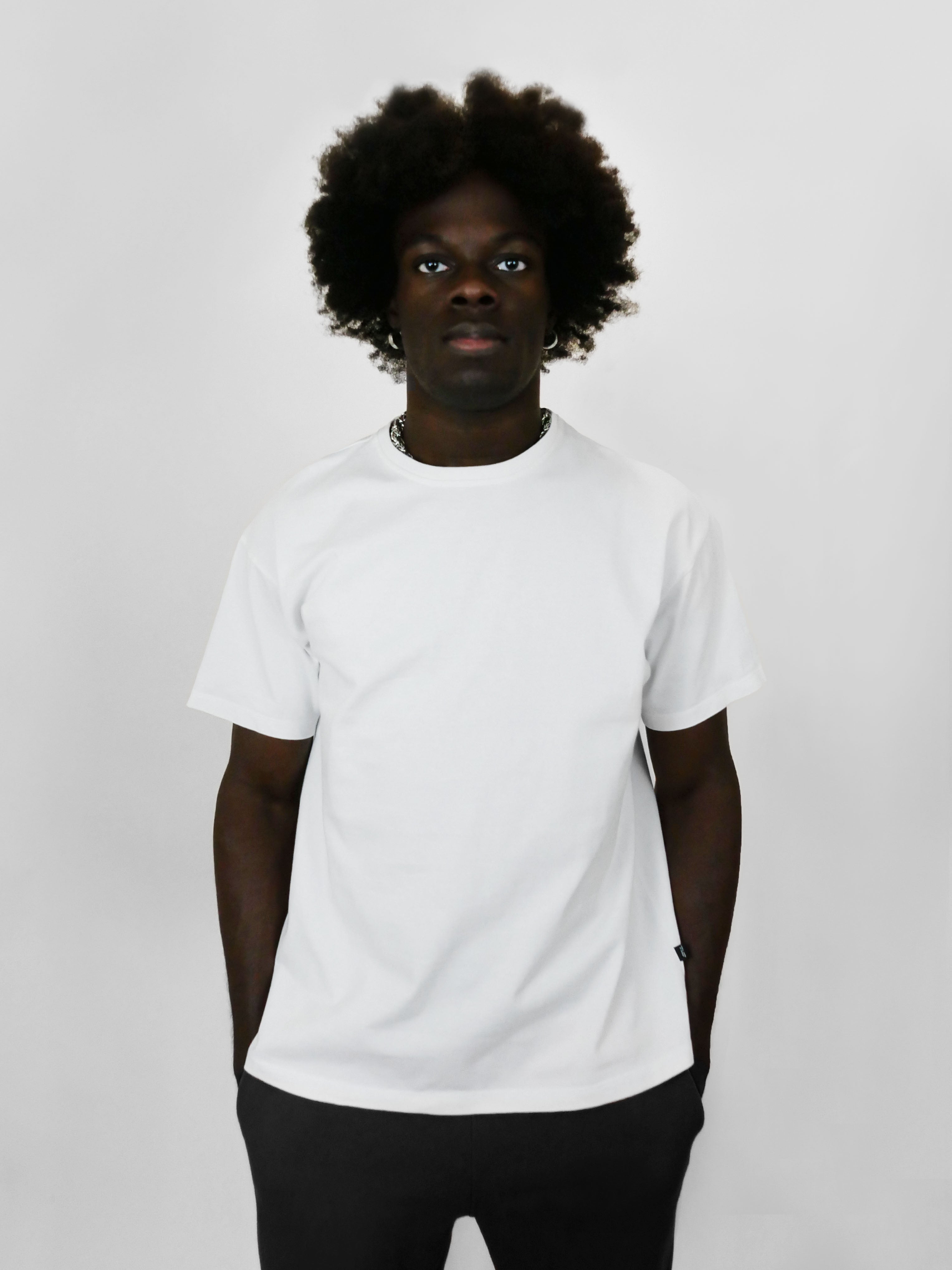 Person wearing a plain white t-shirt against a light gray background