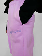 Blush sweatpants with 'blk top KOPE' embroidery on a plain background