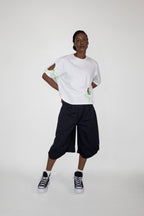 Person wearing a white t-shirt and black shorts on a white background