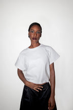 Person wearing a white t-shirt and black skirt on a white background