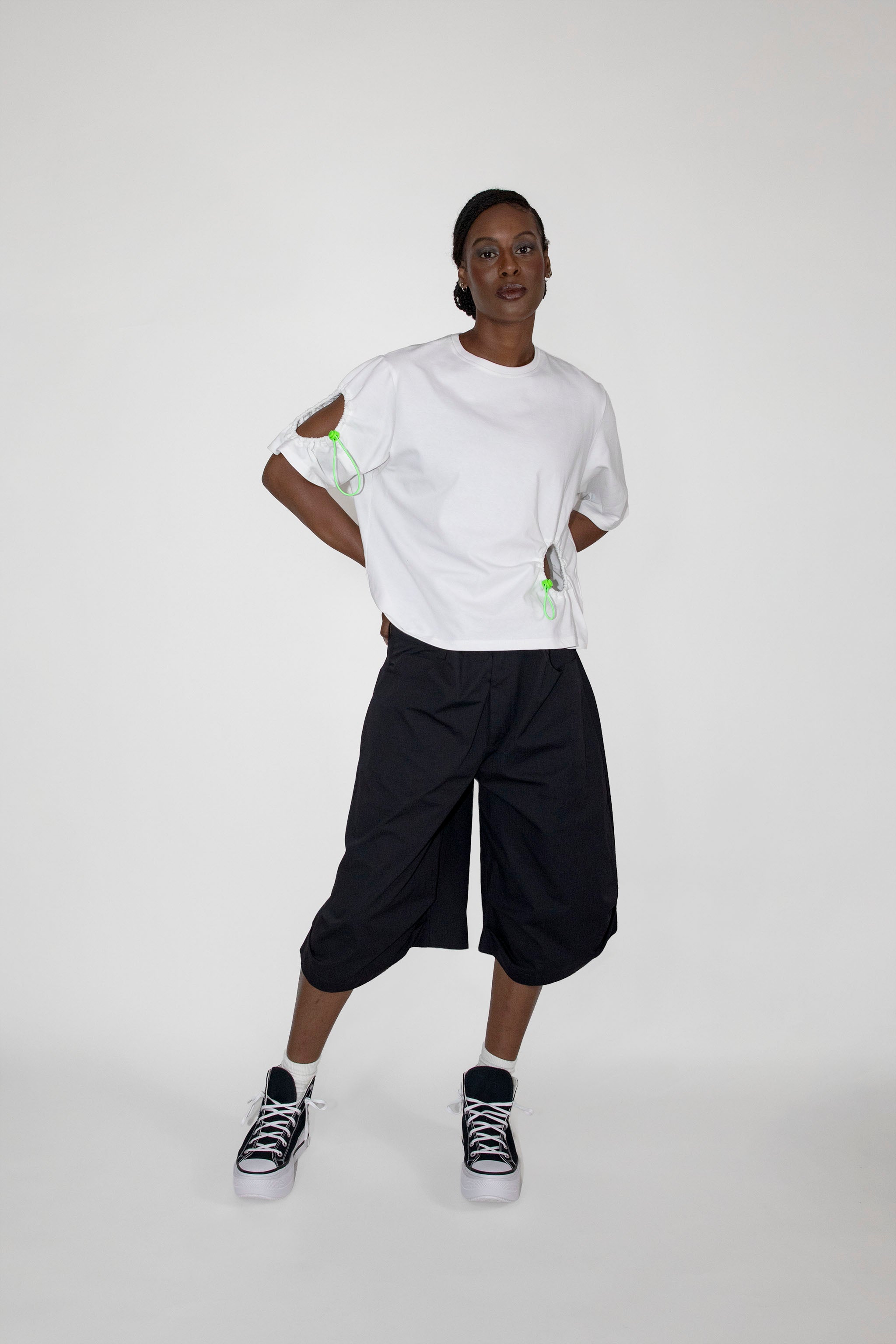 Person wearing a white t-shirt and black shorts on a white background