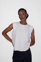 person wearing white sleeveless top and black pants