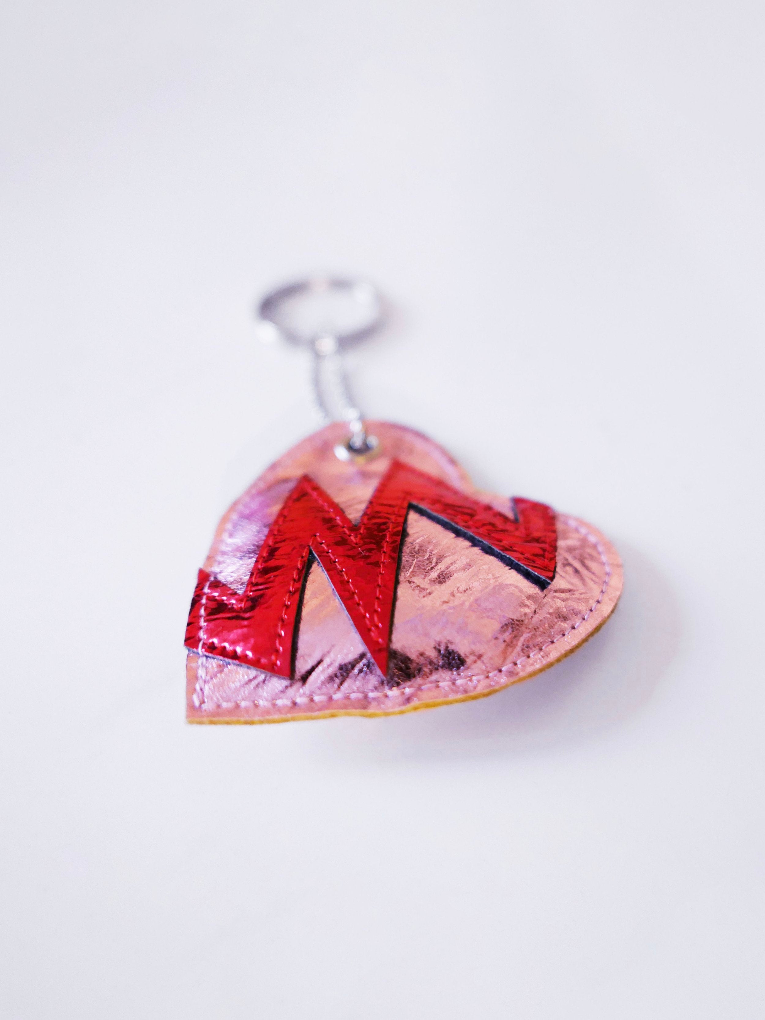 pink heart-shaped keychain indicating a broken heart design on a white background