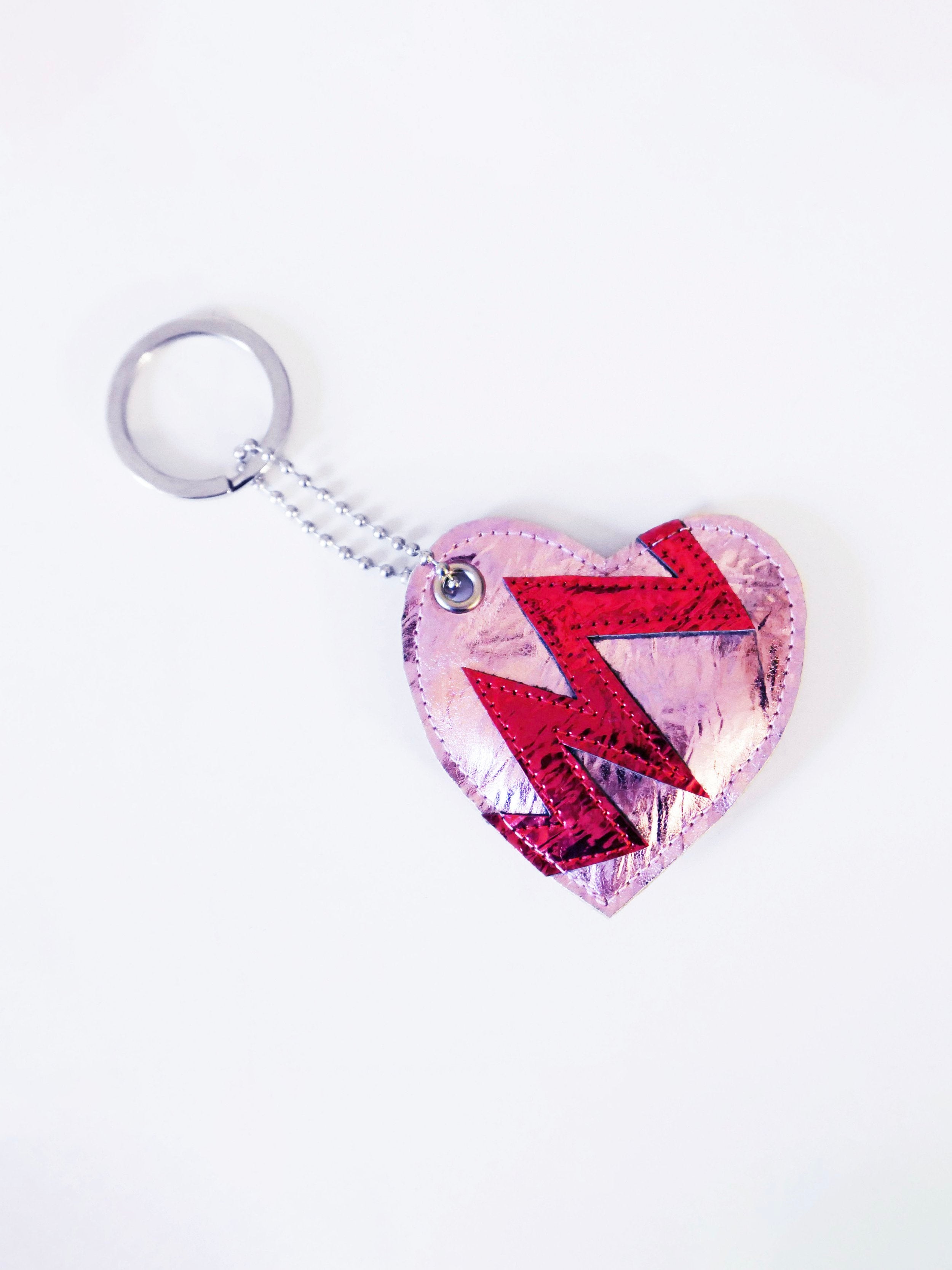 pink heart-shaped keychain indicating a broken heart design on a white background