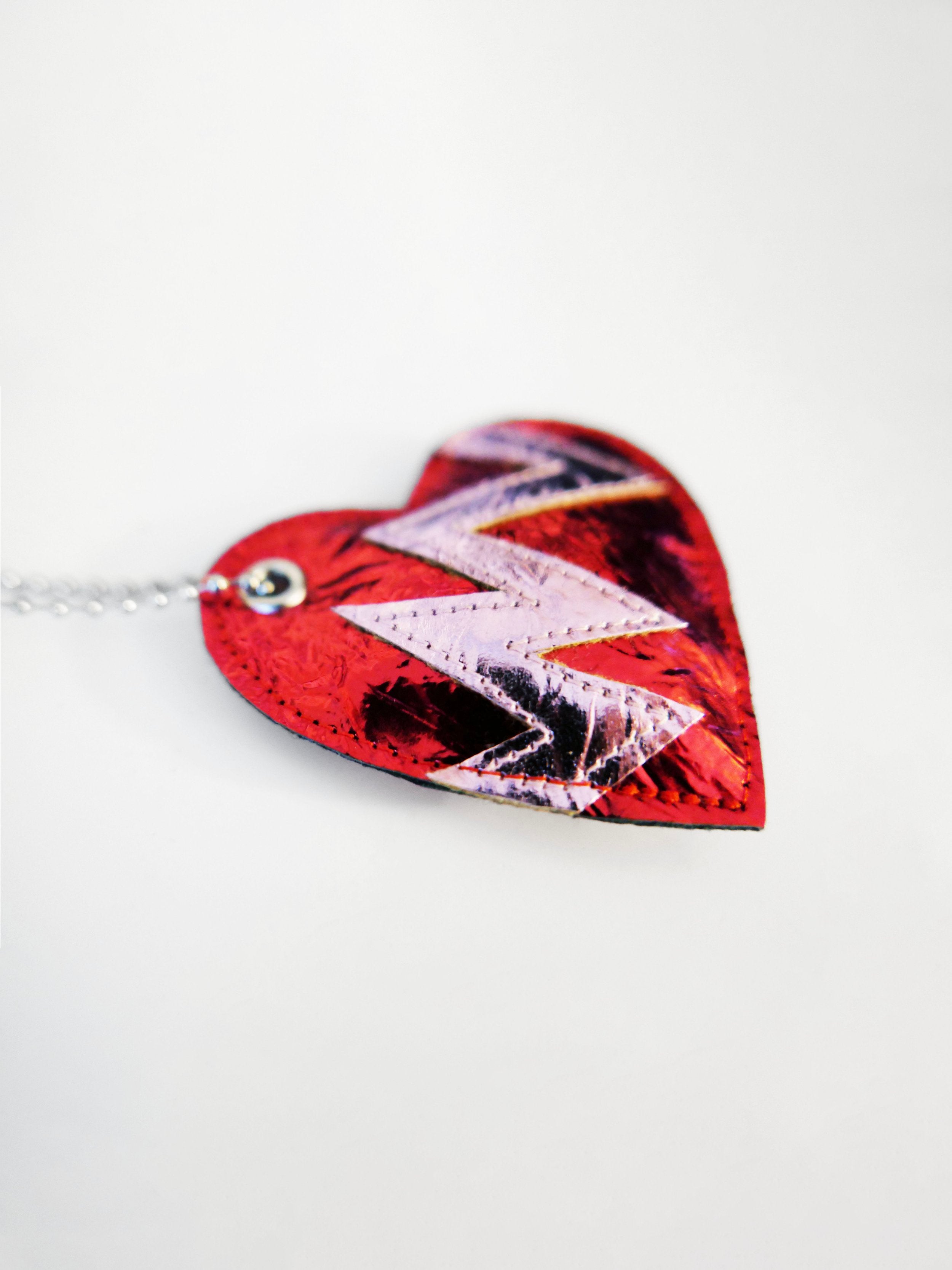 red heart-shaped keychain indicating a broken heart design on a white background