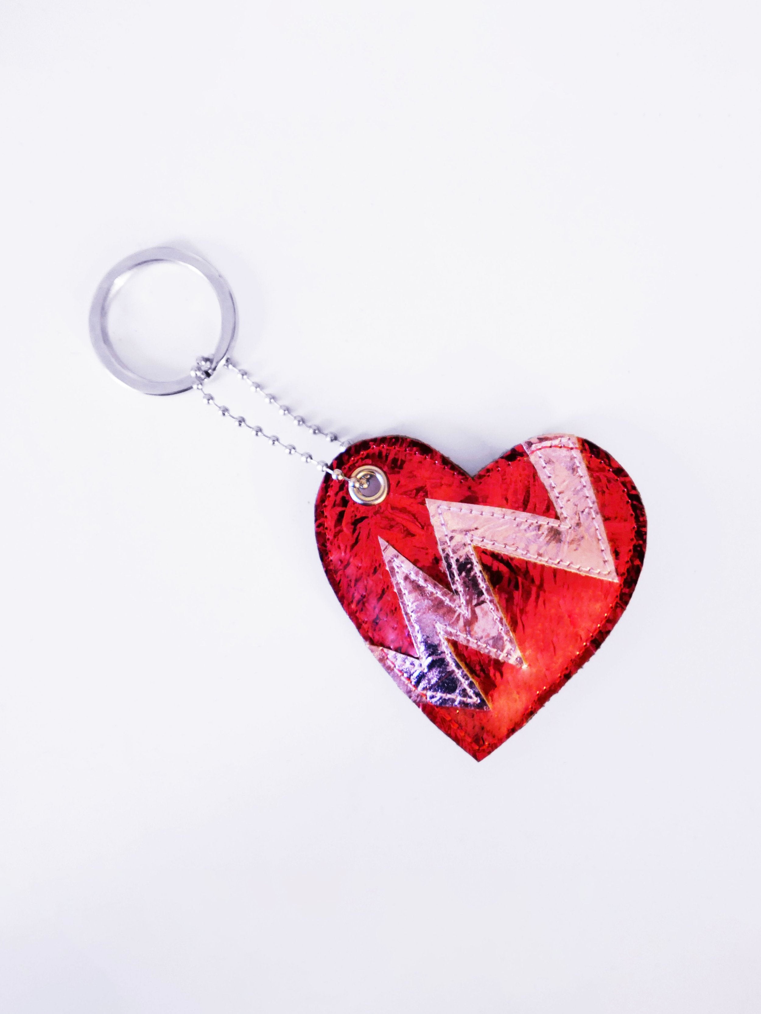 red heart-shaped keychain indicating a broken heart design on a white background