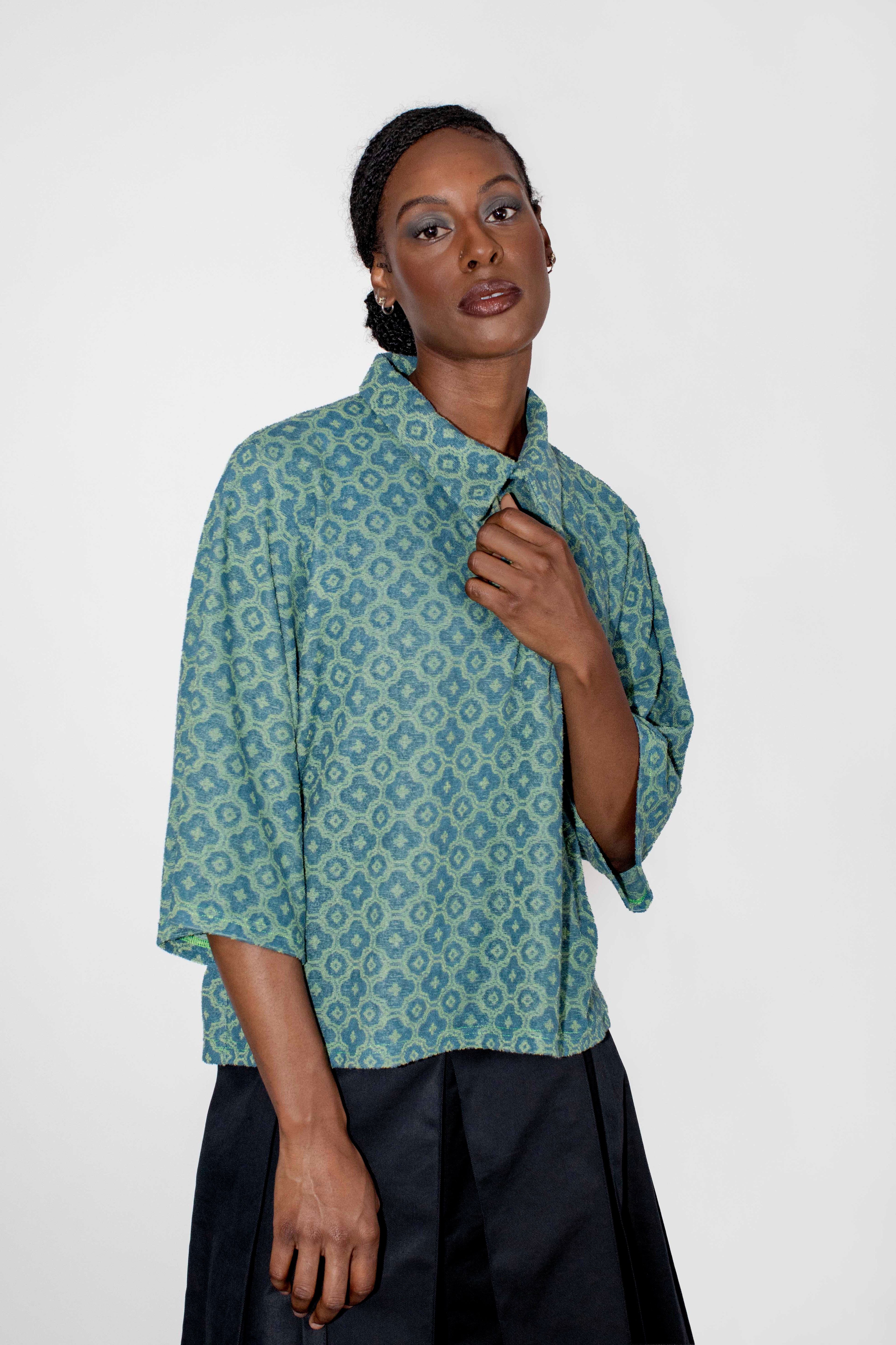 person wearing green and blue patterned polo tee with black skort