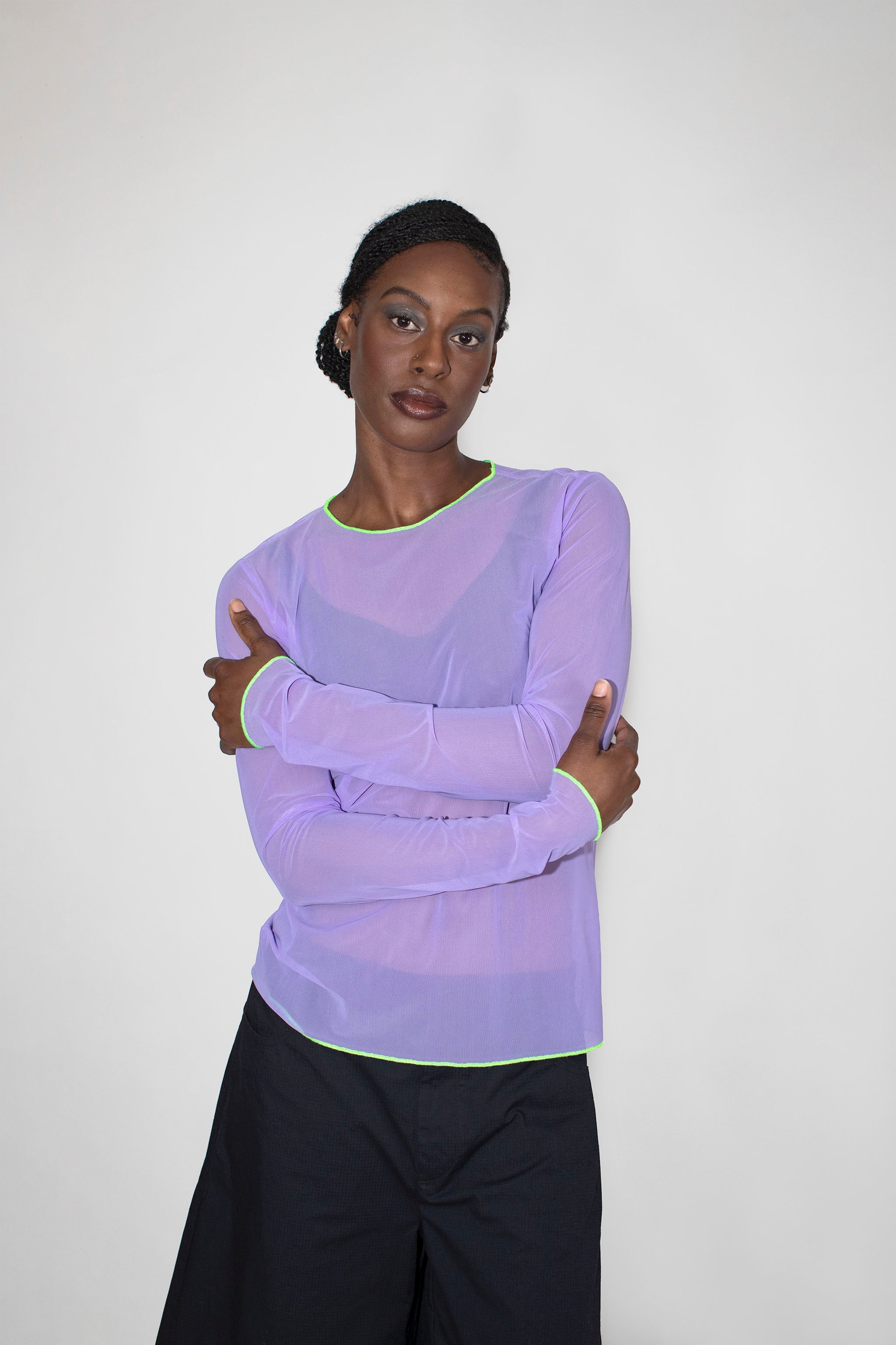Person wearing a light purple long-sleeve top with a white background