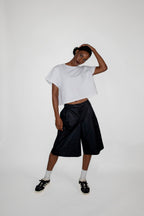 Person wearing a white t-shirt and black shorts on a white background